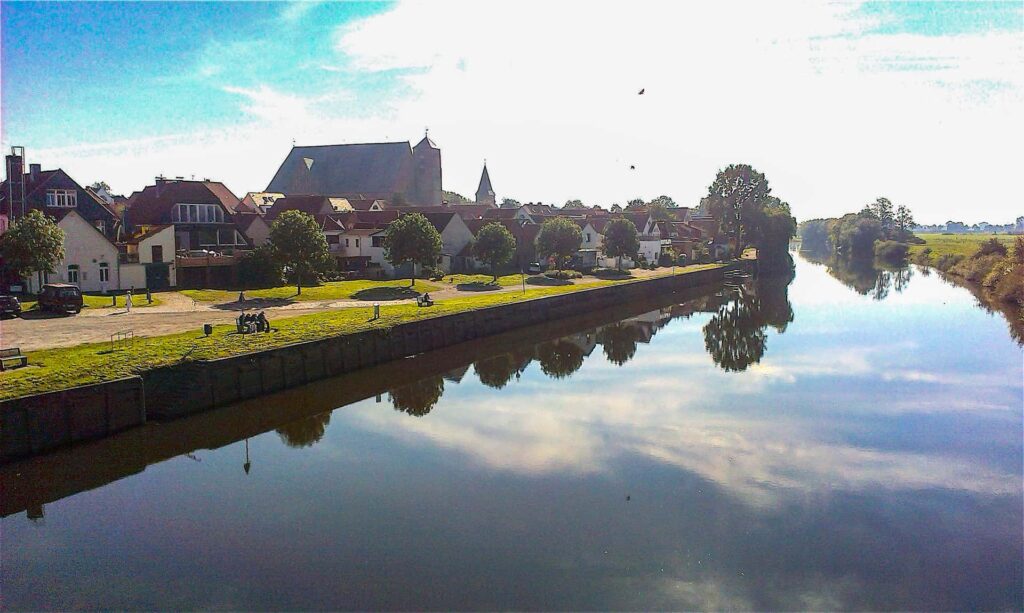 Ein Blick von der Allerbrücke in die Stadt Verden mit der Aller im Vordergrund und dem Dom von Verden im Hintergrund.