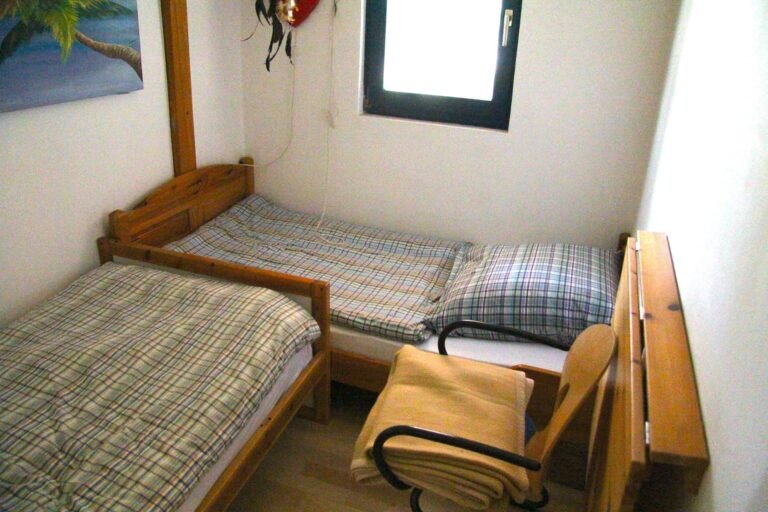 Kleines Schlafzimmer mit zwei Einzelbetten.